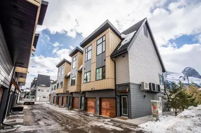 a row of buildings on a street with snow at Casa de Luna by Canadian Rockies Vacation Rentals in Canmore