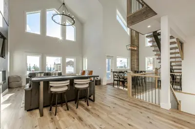 a kitchen and living room with a large island in a house at The White Pearl - Amazing Luxury Chalet with Mountain Views in Big White