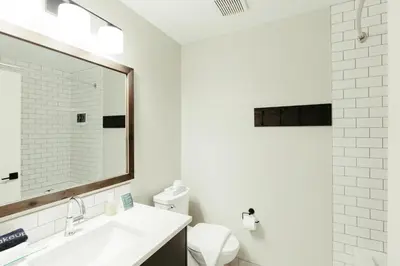 a bathroom with a sink and a toilet and a mirror at Northwinds Hotel Canmore in Canmore