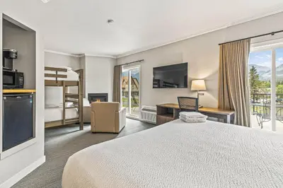 a hotel room with a bed and a balcony at Northwinds Hotel Canmore in Canmore