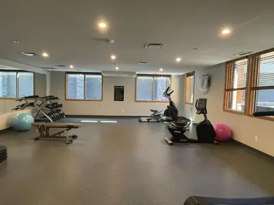a gym with several exercise bikes and exercise balls at BRAND NEW - Gorgeous Spring Creek Penthouse in Canmore