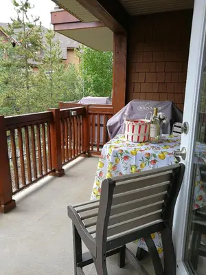 a table on a porch with a table cloth on it at Sunny Tranquil Woods Turret in Falcon Crest Lodge in Canmore