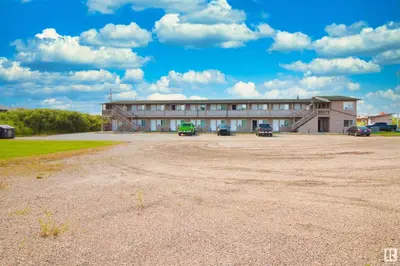 a large building with cars parked in front of it at Kings Court Motel in Cold Lake