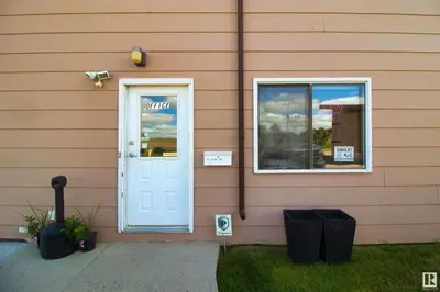 a house with a white door and a window at Kings Court Motel in Cold Lake