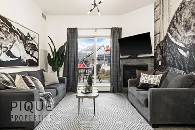 a living room with two couches and a tv at Mountain Haven Retreat, Pool & Hot Tub, UG Parking, Fitness Centre, WiFi! in Canmore