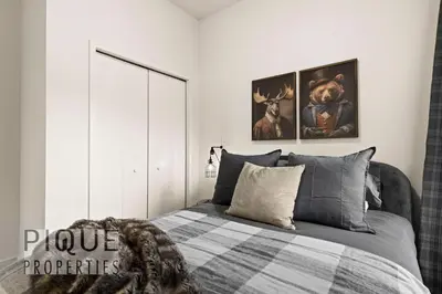 a bedroom with a bed and two pictures on the wall at Mountain Haven Retreat, Pool & Hot Tub, UG Parking, Fitness Centre, WiFi! in Canmore