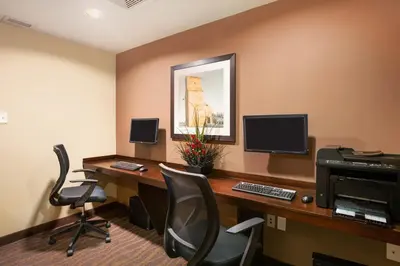 an office with a desk with a computer and chairs at Microtel Inn & Suites by Wyndham Blackfalds in Blackfalds