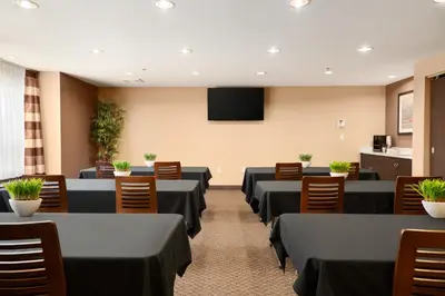 a conference room with tables and chairs and a tv at Microtel Inn & Suites by Wyndham Blackfalds in Blackfalds