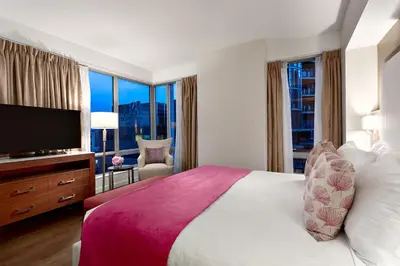 a hotel room with a large bed and a flat screen tv at Auberge Vancouver Hotel in Vancouver