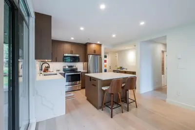 a kitchen with wooden cabinets and a island with bar stools at Ravencrest by Outpost Whistler in Whistler