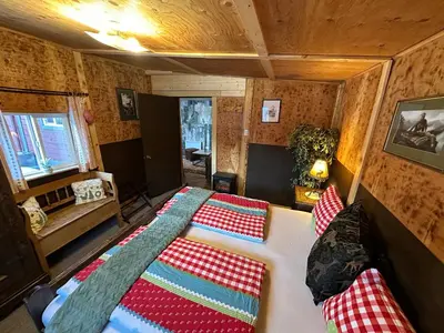 a bedroom with a bed with red and white pillows at The Cabin in Stewart