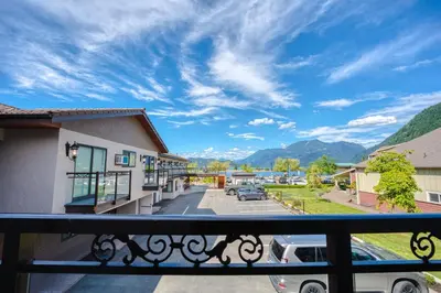 a balcony with a view of a street and mountains at Harrison Grand Motel in Harrison Hot Springs