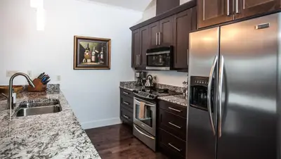 a kitchen with a stainless steel refrigerator and a sink at Alpenglow Penthouse by Revelstoke Vacations in Revelstoke