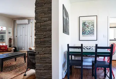 a living room with a dining room table and a brick wall at The Downtown Hive by Revelstoke Vacations in Revelstoke