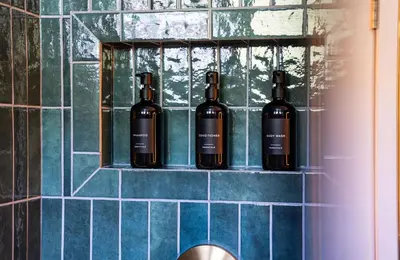 four bottles of wine sitting on a shelf in a bathroom at The Downtown Hive by Revelstoke Vacations in Revelstoke