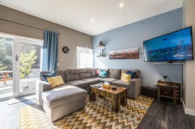 a living room with a couch and a flat screen tv at Pillow Top Condo by Revelstoke Vacations in Revelstoke