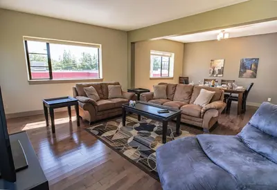 a living room with two couches and a table at Selkirk Snug by Revelstoke Vacations in Revelstoke