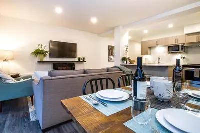 a living room with a table with a bottle of wine at Revelstoke Retreat by Revelstoke Vacations in Revelstoke