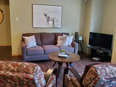 a living room with a couch and a table at Give Something Back Retreat by Revelstoke Vacations in Revelstoke
