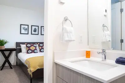 a bathroom with a sink and a bed at The Mac Shack by Revelstoke Vacations in Revelstoke