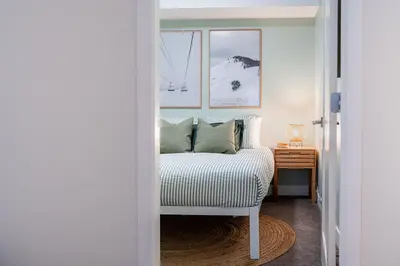 a bedroom with a bed and a table with a nightstand at Powder Village Retreat by Revelstoke Vacations in Revelstoke
