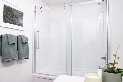 a bathroom with a shower with a glass door at Powder Village Retreat by Revelstoke Vacations in Revelstoke