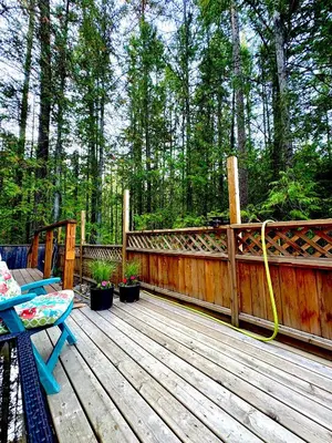 a wooden deck with a yellow hose on it at Forest Nook in Queens Bay