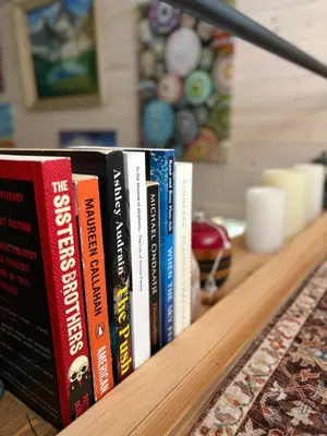 a row of books sitting on a shelf at Forest Nook in Queens Bay