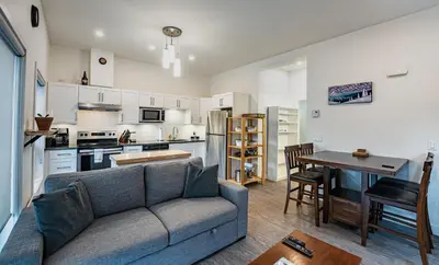 a living room with a couch and a kitchen at Niska's Den by Revelstoke Vacations in Revelstoke