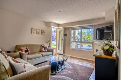 a living room with a couch and a tv at Mountain getaway condo - 5 min walk to the beach! in Invermere