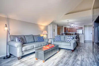 a living room with two couches and a table at Mountain getaway condo - 5 min walk to the beach! in Invermere