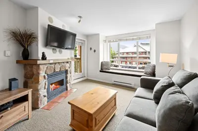a living room with a couch and a fireplace at Bear Lodge One Bedroom by MVA in Whistler