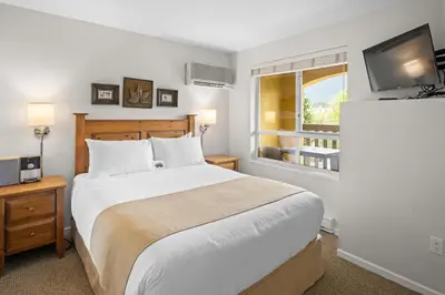 a bedroom with a large bed and a window at Bear Lodge One Bedroom by MVA in Whistler