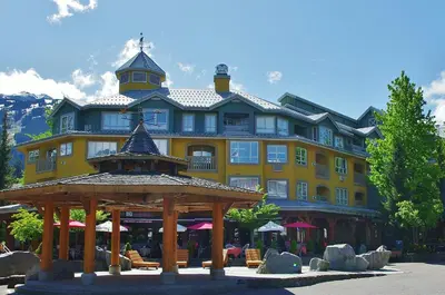 a large yellow building with a gazebo in front of it at Bear Lodge One Bedroom by MVA in Whistler