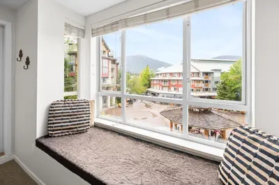 a window seat with a view of a city at Bear Lodge One Bedroom by MVA in Whistler