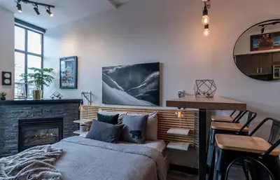 a bedroom with a bed and a fireplace at Alpenglow Lodge Queen Boho Studio by MVA in Whistler