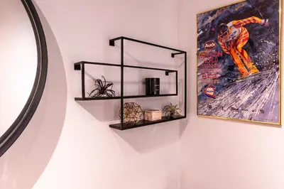 a wall with two black shelves and a picture at Alpenglow Lodge Queen Boho Studio by MVA in Whistler