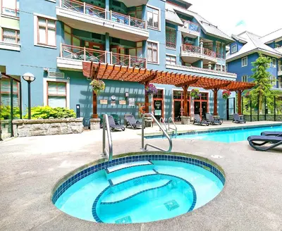 a large swimming pool in front of a building at Alpenglow Lodge Queen Boho Studio by MVA in Whistler