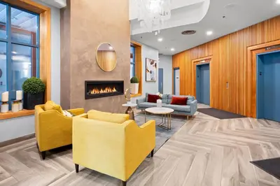 a lobby with yellow chairs and a fireplace at Alpenglow Lodge Queen Boho Studio by MVA in Whistler