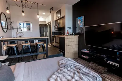 a living room with a large flat screen tv at Alpenglow Lodge Queen Boho Studio by MVA in Whistler