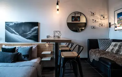 a living room with a couch and a table and a mirror at Alpenglow Lodge Queen Boho Studio by MVA in Whistler