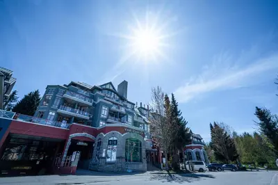 a large building with the sun in the sky at Alpenglow Lodge Snooze Studio with Den by MVA in Whistler