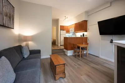 a living room with a couch and a kitchen at Alpenglow Lodge Snooze Studio with Den by MVA in Whistler