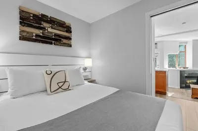 a bedroom with a large white bed and a window at Alpenglow Lodge Snooze Studio with Den by MVA in Whistler