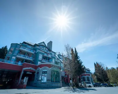 a large building with the sun in the sky at Alpenglow Lodge Sunny Studio with Sitting Area by MVA in Whistler