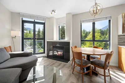 a living room with a table and a fireplace at Alpenglow Lodge Two Bedroom Apartment by MVA in Whistler