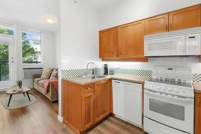 a kitchen with white appliances and a couch at Alpenglow Lodge Junior One Bedroom by MVA in Whistler