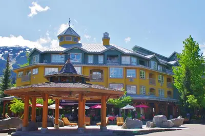 a large yellow building with a gazebo in front of it at Bear Lodge Two Bedroom by MVA in Whistler