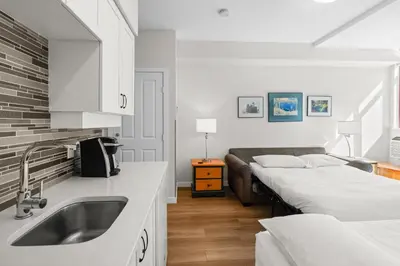 a kitchen with two beds and a sink at Alpenglow Lodge Studio with park view by MVA in Whistler
