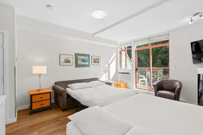a bedroom with two beds and a window at Alpenglow Lodge Studio with park view by MVA in Whistler